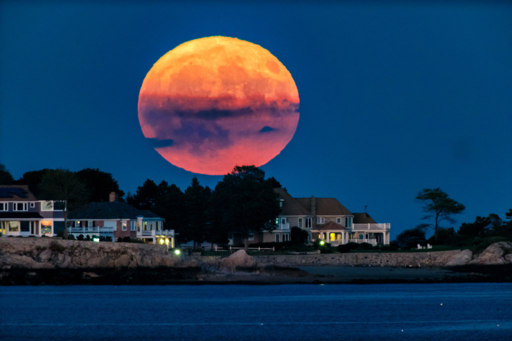 Full moon rising over oceanfront houses