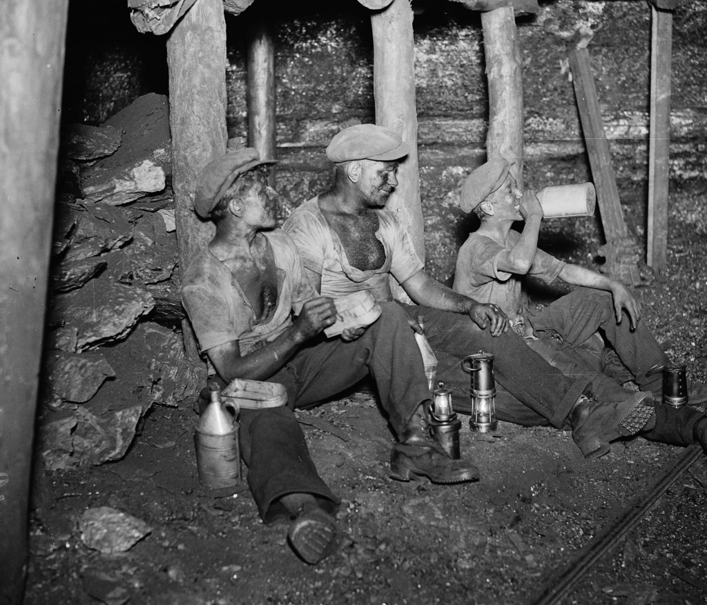 Welsh miners, 1931 Black and white photograph of three welsh miners, sat on ground on their lunch break